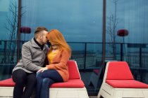 Romantique jeune couple assis à l'extérieur sur le toit-terrasse — Photo de stock