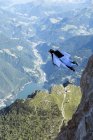 Male BASE jumper wingsuit flying over valley, Dolomites, Italy — Stock Photo
