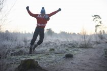 Uomo che salta nella scena invernale rurale — Foto stock