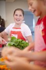 Les adolescentes préparent des légumes dans la cuisine — Photo de stock