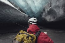 Чоловік перетинав річку з мотузкою в крижаній печері, льодовик Ватнажоль, Національний парк Ватнажокль, Ісландія — стокове фото