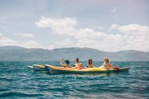 Cuatro amigas jóvenes haciendo kayak en el lago Atitlán, Guatemala - foto de stock