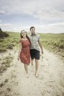 Junges Paar läuft barfuß auf sandigem Weg, gemütlich, wummernd, usa — Stockfoto