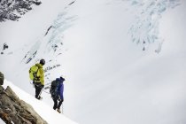 Montañistas esquiando en montaña cubierta de nieve, Saas Fee, Suiza - foto de stock