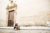 Couple using mobile phone on pavement, Palma de Mallorca, Spain — Stock Photo
