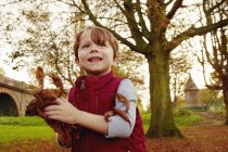 Мальчик бросает осенние листья — стоковое фото
