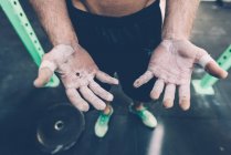Close up of male cross trainer chalked hands in gym — Stock Photo