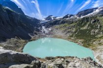 Trift Lake surrounded by mountains under blue sky — Stock Photo