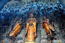 Стена, полная золотых и каменных статуй Будды — стоковое фото