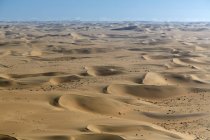 Vista aérea de las dunas de arena bajo el cielo azul - foto de stock