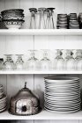 Shelves with glasses, plates and bowls — Stock Photo