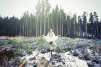 Femme adulte moyenne pratiquant la pose debout d'arbre yoga dans la forêt — Photo de stock