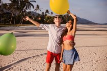 Junges Paar am Strand mit Blick auf Luftballons, koh samui, thailand — Stockfoto