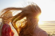 Mother and daughter walking on windy beach — Stock Photo