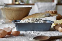 Bread loaves and dough in messy kitchen — Stock Photo