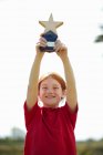 Chica animando con trofeo al aire libre - foto de stock