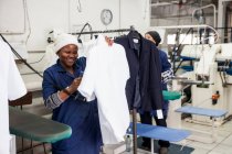 Camisa de planchar para trabajadores en fábrica de prendas de vestir - foto de stock