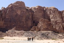 Tres excursionistas que caminan en Wadi Rum, Jordania - foto de stock