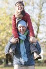 Father and son in park, father carrying son on shoulders, laughing — Stock Photo