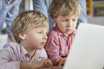 Meninos usando laptop juntos em casa — Fotografia de Stock