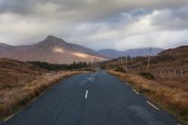 Звивиста дорога в гірському пейзажі під хмарним небом — стокове фото