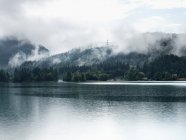 Fog over mountains and still lake — Stock Photo
