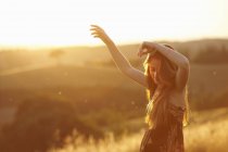 Teenager dancing in field at dusk — Stock Photo