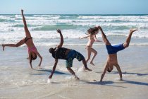Jeune groupe frémissant sur la plage — Photo de stock