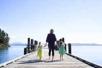 Mitte erwachsene Frau und Töchter flanieren auf der Seebrücke, Neuseeland — Stockfoto