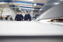 Manager mentoring worker on production line in roller blind factory — Stock Photo