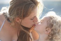 Ritratto di giovane ragazza baciare sorella maggiore — Foto stock