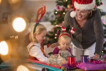 Mutter und Töchter wickeln Weihnachtsgeschenke ein — Stockfoto