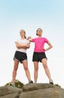 Портрет двох гордих жіночих бігунів на вершині скельного формування — стокове фото