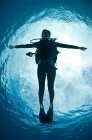 Visão frontal completa dos braços do mergulhador aberto flutuando perto da superfície da água olhando para a câmera, Chinchorro Atoll, Quintana Roo, México — Fotografia de Stock