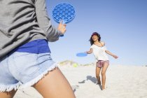 Twp jeunes femmes sur la plage jouer au tennis — Photo de stock