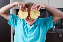 Дівчина тримає ананасові скибочки — стокове фото
