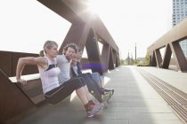 Дві жінки і чоловік штовхають тренування проти міського пішохідного мосту — стокове фото