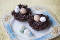 Chocolate easter eggs in chocolate nests on plate — Stock Photo