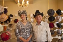 Portrait of senior couple in traditional milliners shop — Stock Photo