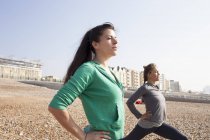 Zwei Frauen beim Aufwärmtraining am Strand von Brighton — Stockfoto