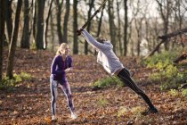 Couple in forest using resistance band — Stock Photo