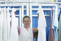 Frau in Waschsalon hängt Wäsche auf — Stockfoto