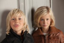 Niños con abrigos de invierno en el interior - foto de stock