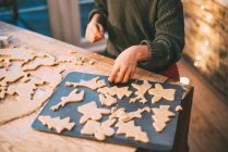 Обрізане зображення хлопчика, який готує різдвяне печиво на кухонній стійці — стокове фото