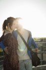 Romantic young couple leaning against fence on rooftop — Stock Photo