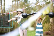 Crianças usando vestido extravagante, brincando no jardim — Fotografia de Stock