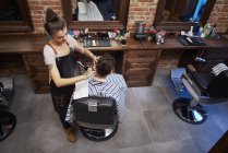 Парикмахер бреет волосы клиента бритвой — стоковое фото