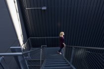 Vista lateral da Mulher descendo escadas — Fotografia de Stock