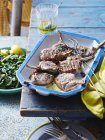 Dish of lemon and mint lamb cutlets on table — Stock Photo
