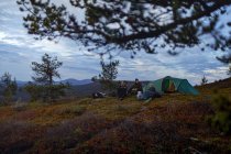 Excursionistas relajándose en el campamento de viaje juntos, Laponia, Finlandia - foto de stock